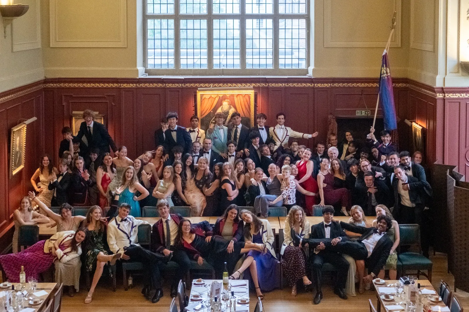 SSBC members in black tie and boat club blazers in Sidney's dining hall, with the club flag